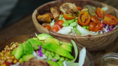 Close up of human hands serving two big appetizing vegetable bowls with fresh Stock Footage 170474318