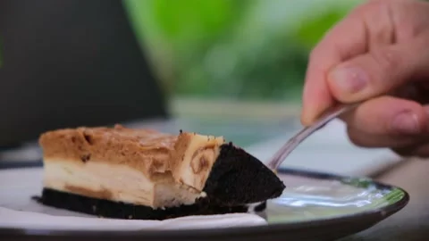 Close up of human hands tapping on laptop and eating tasty cake slice in Stock Footage 168052744