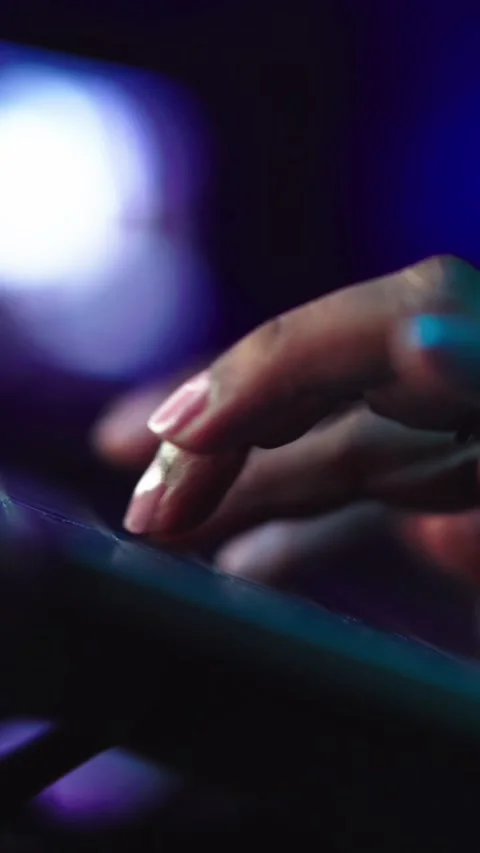 Close up human hands typing on laptop keyboard in dark. Unrecognizable black Stock Footage 275176027