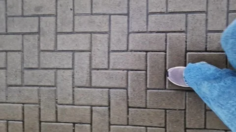 Close-up of human legs walking on a tiled road Stock Footage 305191211