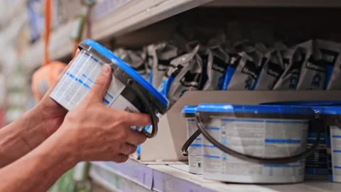 Close up of Human man hands take from the shelf package a can of paint or putty Stock Footage 279550838
