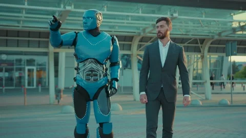 Close up humanoid robot walks down with man talking the street in the city Stock Footage 133302026
