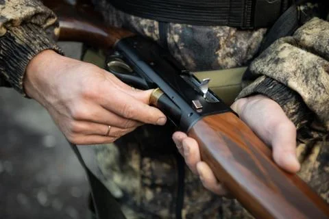 Close-up of a hunter hands loading his shotgun Stock Photos
