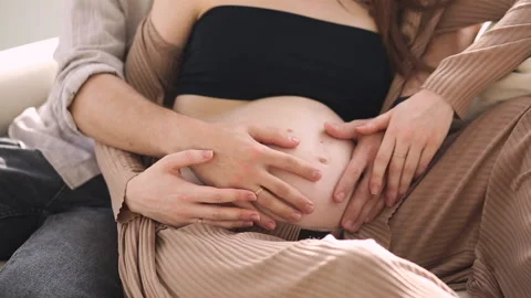 Close-up of a husband touching his woman's pregnant belly. Stock Footage 277317397