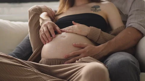 Close-up of a husband touching his woman's pregnant belly. Stock Footage 277317587