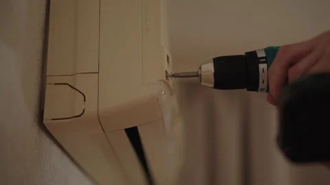 Close-up of Hvac technician using cordless drill to repair air conditioning unit Stock Footage 312376105