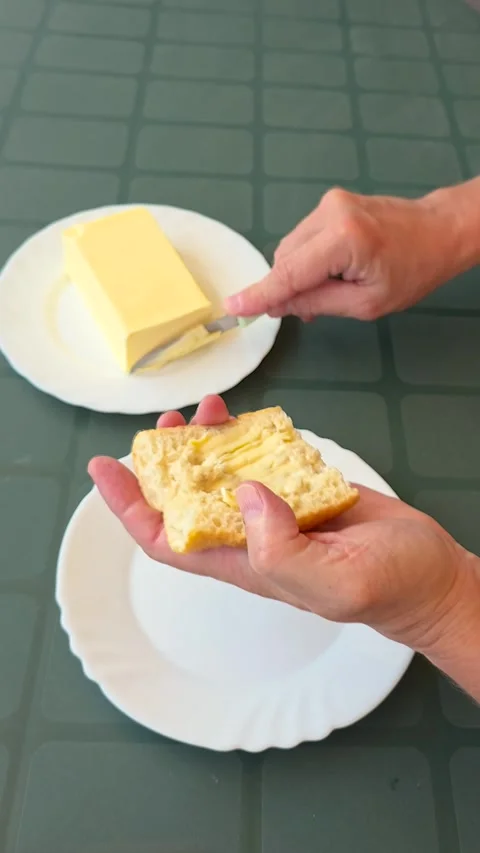 Close up hyperlapse of male hands spreading creamy butter on fresh bread bag Video stock 338110363