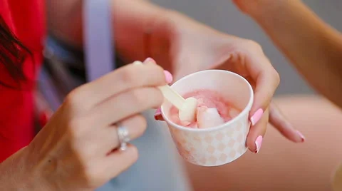 Close up ice cream in hands. Young female model eating ice cream cone on summer Stock Footage