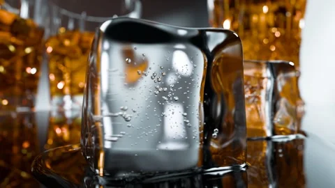 Close-up of Ice Cube with Soda Bubbles and Whiskey Glasses Stock Footage 260908739