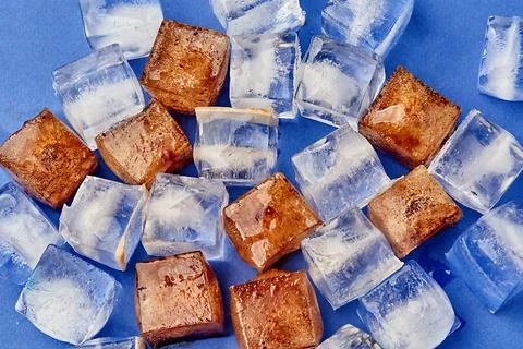 Close-up of ice cubes and cola on a blue background Stock Photos