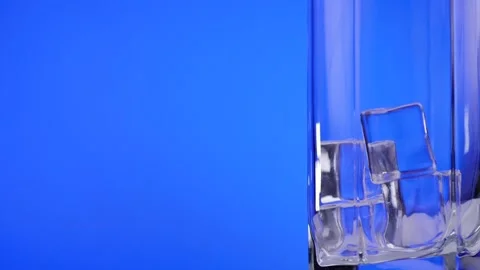 Close-up of ice cubes falling into an empty glass. Slow motion. Stock Footage 130822374