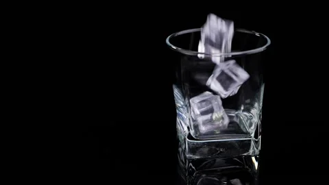 Close-up of ice cubes falling into an empty glass. Slow motion. Stock Footage 131947702
