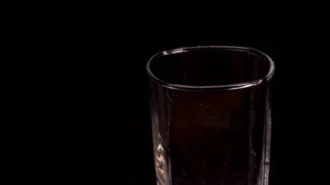 Close-up of ice cubes falling into an empty glass on black background, slow Video stock 150779105