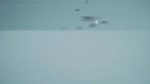 Close-up of ice cubes falling into water in slow motion Video stock 125067072