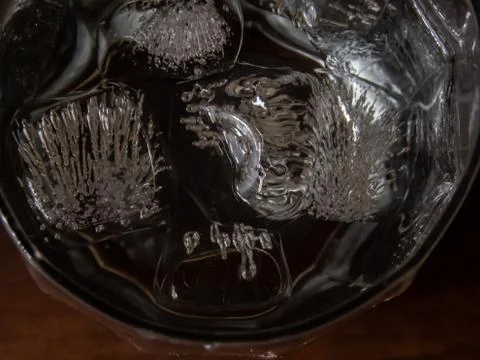 Close up of ice cubes floating on the cold water in glass. Stock Photos