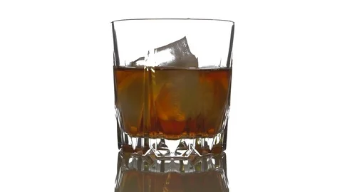 Close-up. Ice cubes rotating and melts in a glass of whiskey Stockbeeldmateriaal 125364075