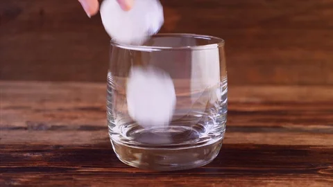 Close Up of Ice Falling and Pouring Whiskey in Glass Video stock 122508025