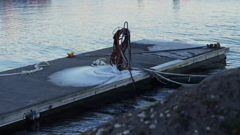 Close up of ice layer on a harbor walkway caused by a water hose in freezin.. Stock Footage 329864671