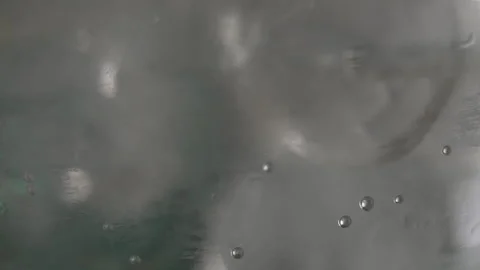 Close up of ice swirling inside of a clear drink cocktail making Stock Footage 213289203