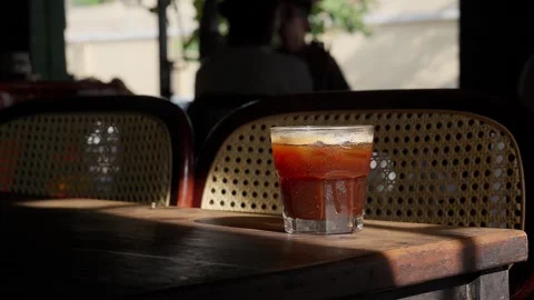 Close up iced brown coffee on an old wooden table in a sunbeam 스톡 동영상 343629615