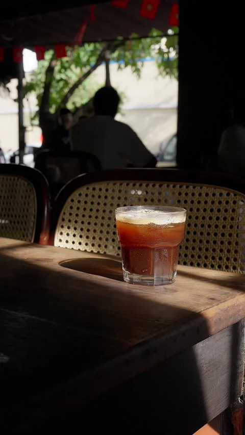 Close up iced brown coffee on an old wooden table in a sunbeam 스톡 동영상 343629693