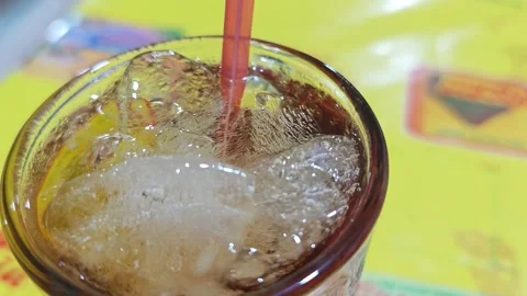 Close up of iced tea served in a transparent glass with a red straw 스톡 동영상 336830842