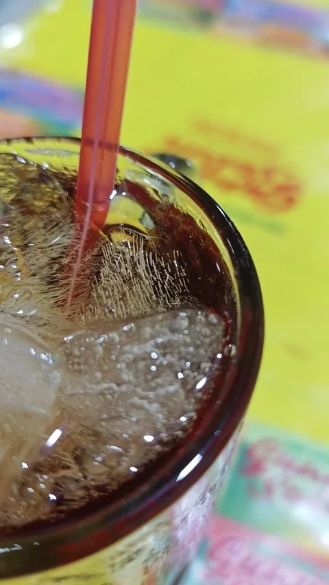 Close up of iced tea served in a transparent glass with a red straw 스톡 동영상 336830844