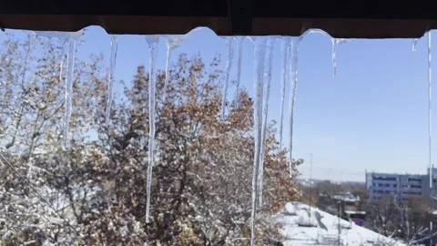 Close-Up Icicles Above Window With Winter Sky and City Background Stock Footage 330227595