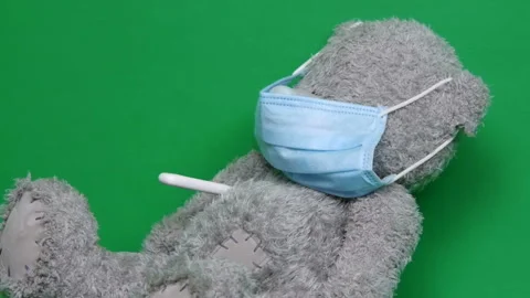 Close-up. Ill teddy bear. An ill teddy bear wear a medical mask on it face. And Video stock 126862067