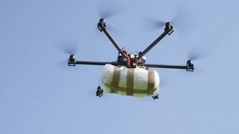CLOSE UP: Illegal cargo drone flying big narco drugs package against blue sky Stock Footage 81139857
