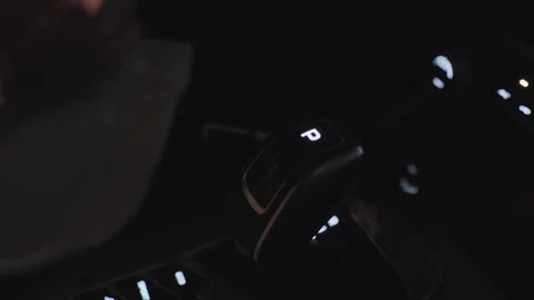 Close up of illuminated car gear selector in park mode with driver hand Video stock 307788440