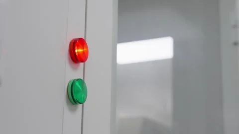 Close-up of an illuminated red indicator above a green button on a sleek Stock Footage 325868070