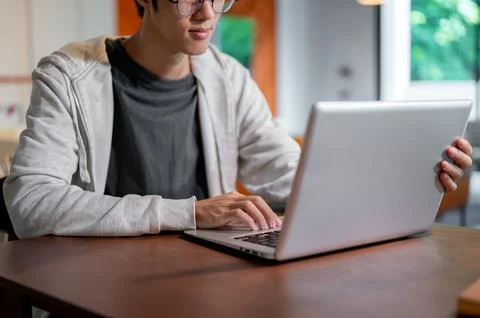 A close-up image of an Asian man working on his laptop computer and working.. Stock Photos