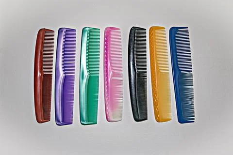 Close up image of assorted colorful plastic hair straightener combs on plain  Stock Photos