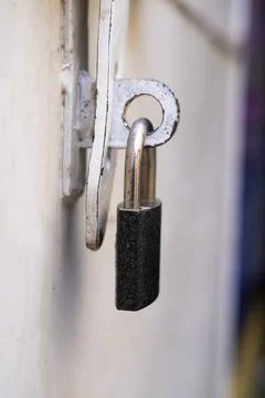 Close-up image of a black and silver lock hanging from a weathered, vintage.. Stock Photos