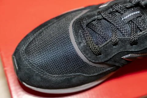 Close-up image of a black sneaker showcasing its textured surface, laces, and 库存照片