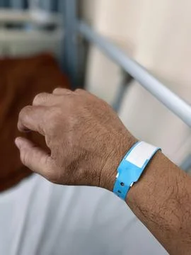 Close-up image of a blue plastic bracelet on the arm of an adult male inpat.. Stock-Fotos