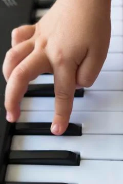 Close up image of child's hand playing on the piano Stock Photos
