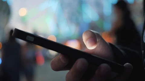 Close-up image of a child's hands using a smartphone at night on a city shopping Vídeo Stock 94507914