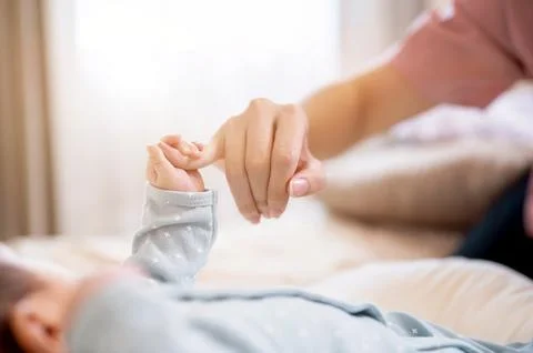 A close-up image with a copy space of a newborn baby holding his mom's fing.. Stock Photos