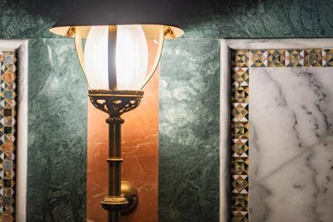 Close-up image of a decorated wall, with a turned-off lamp and intricate pa.. Stock Photos