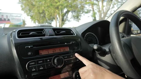 Close up image of driver's hand press button on car audio system, listening m Stock Footage 146633572