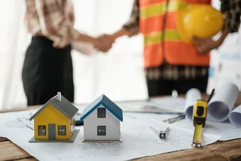 Close-up image of an engineer shaking hands with his coworker during the meeting Stock Photos