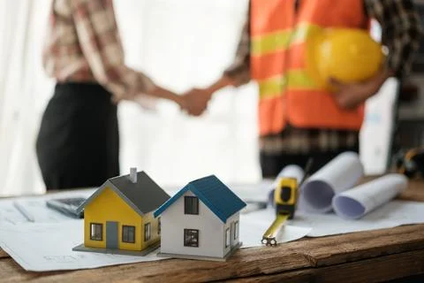 Close-up image of an engineer shaking hands with his coworker during the meeting Stock Photos