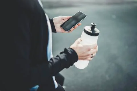Close-up image of female jogger using modern smartphone outside Stock Photos