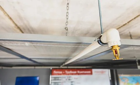 Close up image of fire sprinkler with fire in background. Fire sprinklers are Foto stock