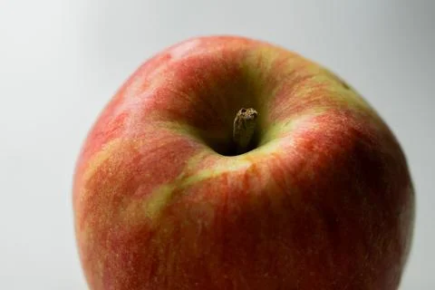 A close-up image of a fresh red and green apple with a smooth surface on a white Stock Photos