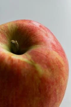 A close-up image of a fresh red and green apple with a smooth surface on a white Stock Photos