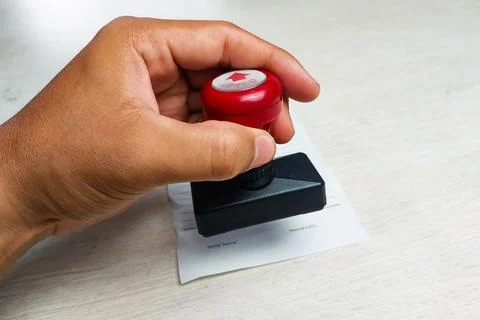 Close up image of a hand stamping a document on a table. The concept of bus.. Stock Photos