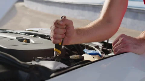 Close-up image of the hands of a car mechanic who performs repairs with the key Stock Footage 279807377